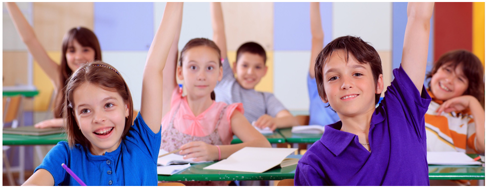 Children in classroom, arms raised.